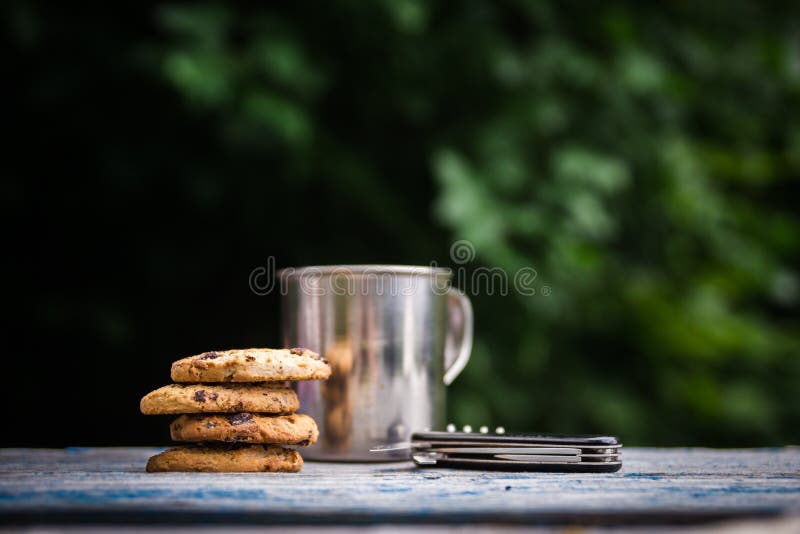 Galletas, taza turística del metal en una tabla al aire libre imágenes de archivo libres de regalías Galletas, taza turística del metal en una tabla al aire libre imágenes de archivo libres de regalías
