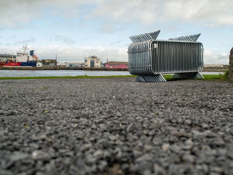 10/04/2019 Galway / Ireland: Stack of metal security fences by river Corrib, Port in the background royalty free stock photography