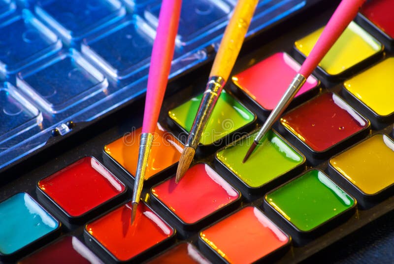 Gama de colores de las pinturas de la acuarela con tres cepillos fotografía de archivo libre de regalías Gama de colores de las pinturas de la acuarela con tres cepillos fotografía de archivo libre de regalías