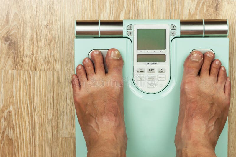 Gamala mannen står på en modern skala Mäta fetthalten av kroppen Intelligent medicinsk vikt Begreppet av obesien royaltyfria bilder Gamala mannen står på en modern skala Mäta fetthalten av kroppen Intelligent medicinsk vikt Begreppet av obesien royaltyfria bilder