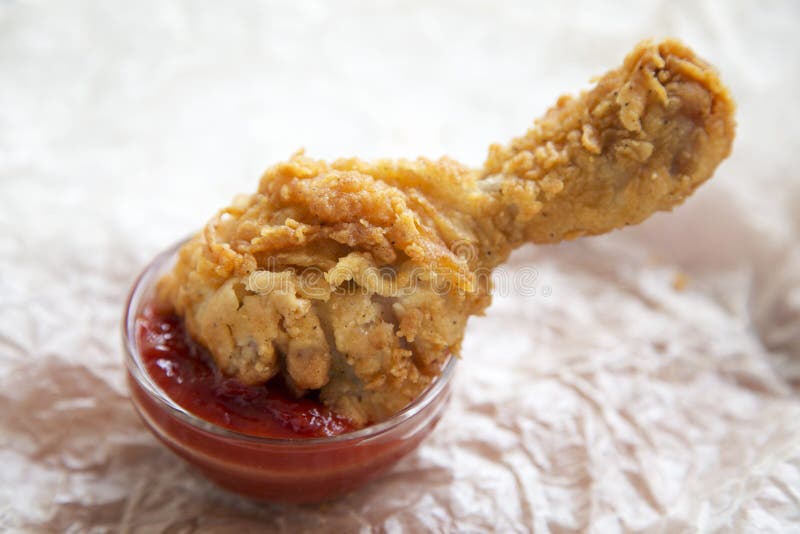 Gamba di pollo fritto in una ciotola di salsa, vista laterale fotografie stock libere da diritti Gamba di pollo fritto in una ciotola di salsa, vista laterale fotografie stock libere da diritti