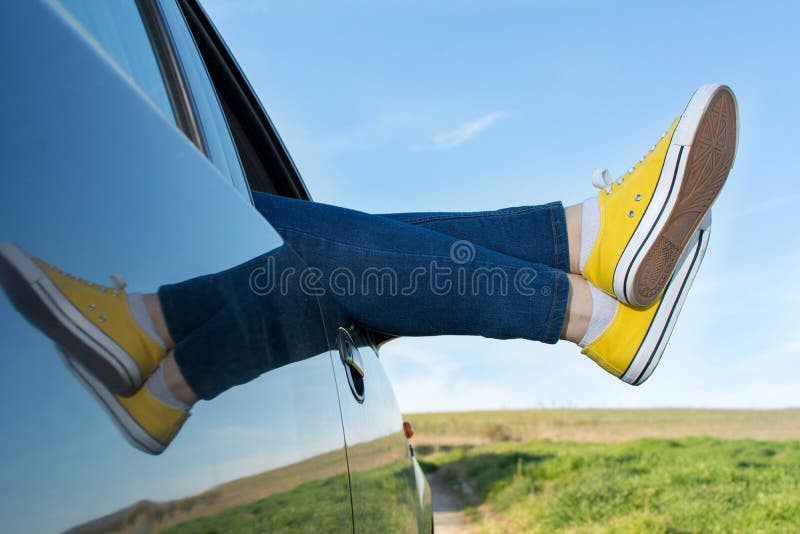 Gambe della donna dalla finestra di automobile immagine stock libera da diritti Gambe della donna dalla finestra di automobile immagine stock libera da diritti