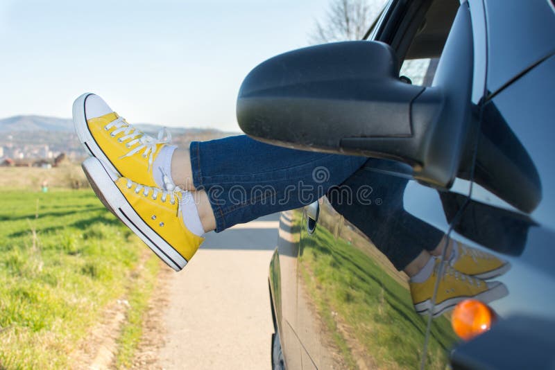 Gambe della donna dalla finestra di automobile fotografie stock libere da diritti Gambe della donna dalla finestra di automobile fotografie stock libere da diritti