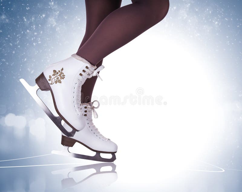 Gambe della donna negli stivali di pattinaggio su ghiaccio
