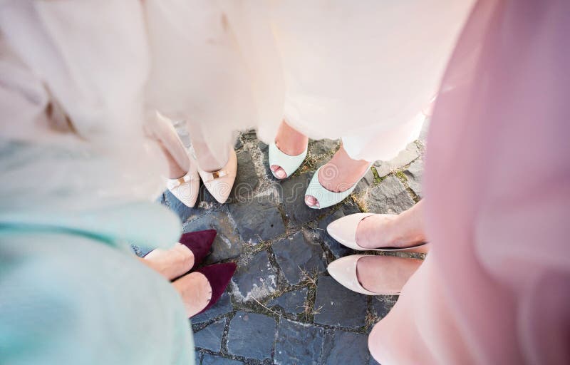 Gambe delle damigelle d'onore Sposa con le sue amiche a colori bei vestiti nella festa nuziale fotografie stock Gambe delle damigelle d'onore Sposa con le sue amiche a colori bei vestiti nella festa nuziale fotografie stock