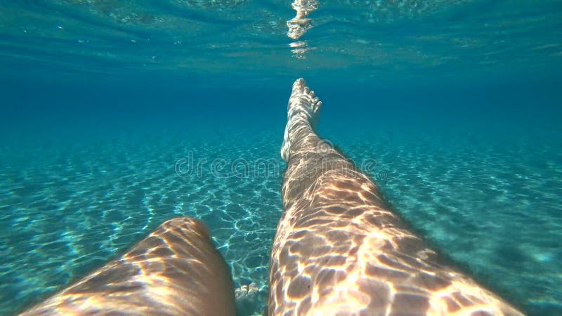 Gambe maschili spruzzate sotto l'acqua nel mare adriatico