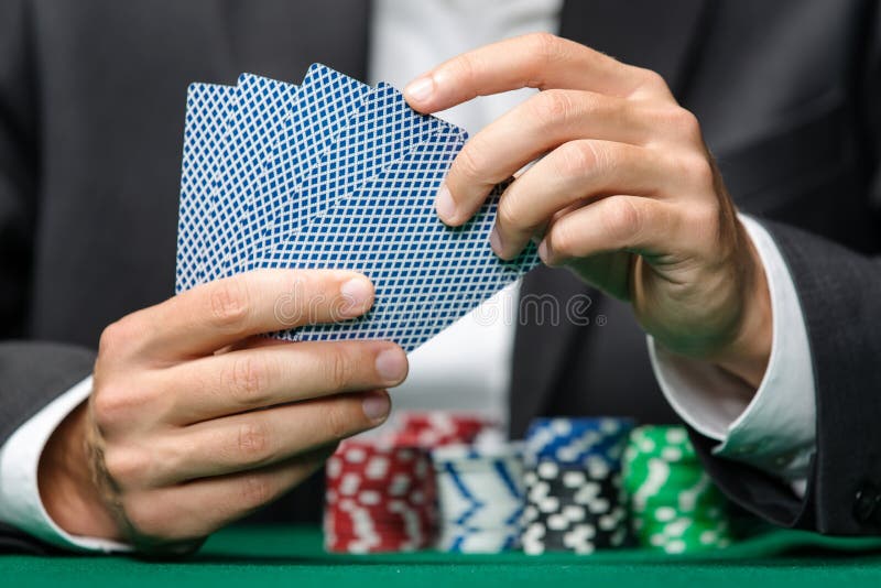 Gambler playing poker cards with poker chips on the table stock image Gambler playing poker cards with poker chips on the table stock image