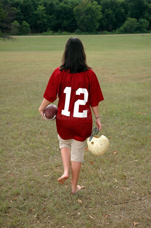 Young woman leaving field after football game. Young woman leaving field after football game.