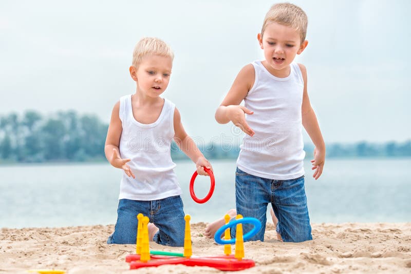 Two Brothers are Walking and Playing on the Beach.the Game is a Ring