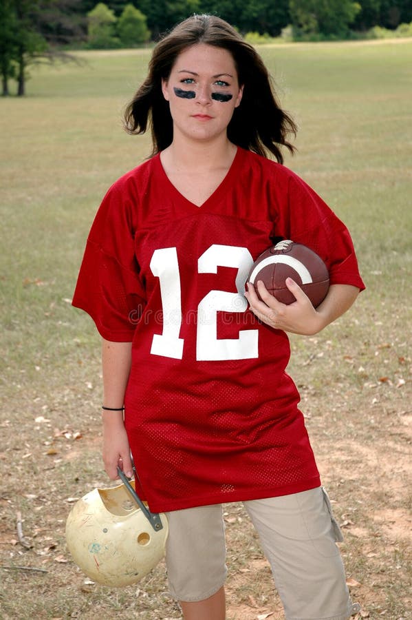 Young woman holding football and helmet. War paint. Young woman holding football and helmet. War paint.