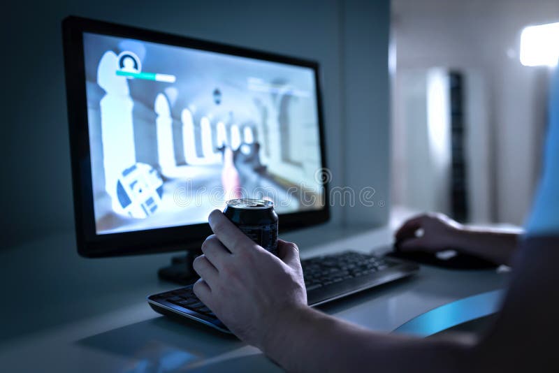 Gamergrabben som spelar videospelet och dricker sodavatten eller energidrinken från kan Fps videogame i datorbildskärm royaltyfri foto Gamergrabben som spelar videospelet och dricker sodavatten eller energidrinken från kan Fps videogame i datorbildskärm royaltyfri foto