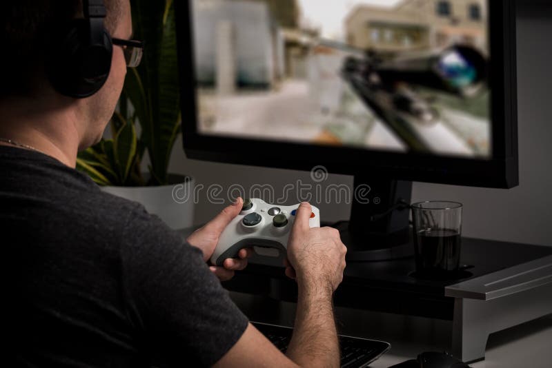 Free Photo  Gamer using controller to play online video games on computer.  man playing game with joystick and headphones in front of monitor. player  having gaming equipment, doing fun activity.