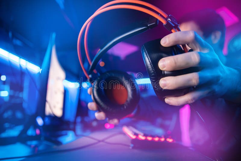 Happy professional player streaming esport tournament using microphone and  headphones, enjoying a multiplayer game. Competitive gamer playing online  video game at home. Neon color. Cyber sport concept Stock Photo