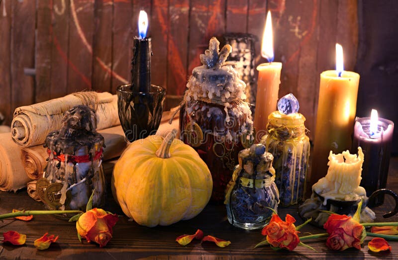 Old paper scrolls, pumpkin, candles and magic bottles on witch table. Wicca, esoteric, Halloween and occult background with vintage magic objects for mystic rituals. Old paper scrolls, pumpkin, candles and magic bottles on witch table. Wicca, esoteric, Halloween and occult background with vintage magic objects for mystic rituals