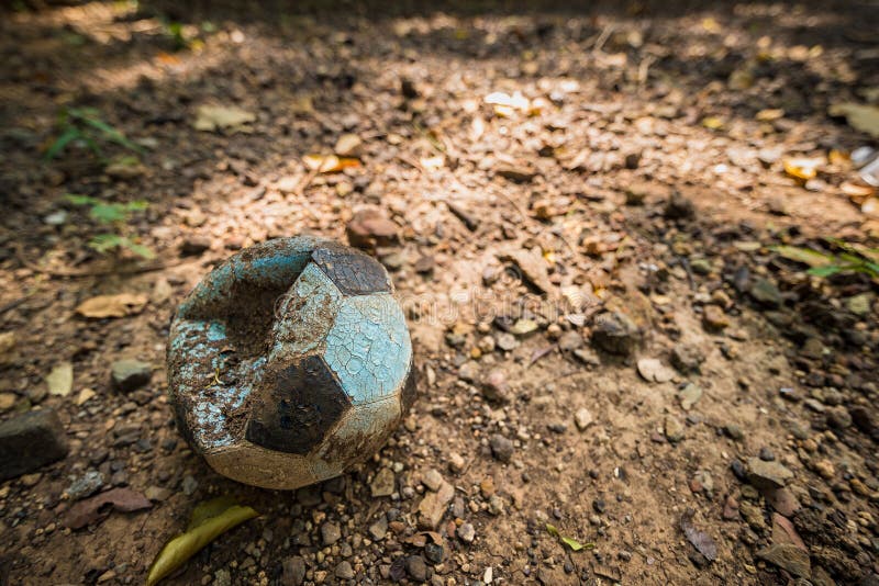 Gammal deflaterad fotbollboll på fältet thailand royaltyfri bild Gammal deflaterad fotbollboll på fältet thailand royaltyfri bild