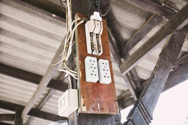 Gammal elektrisk växlingmaktsäkerhetsbrytare och AC-uttagproppar på det wood brädet royaltyfri bild Gammal elektrisk växlingmaktsäkerhetsbrytare och AC-uttagproppar på det wood brädet royaltyfri bild
