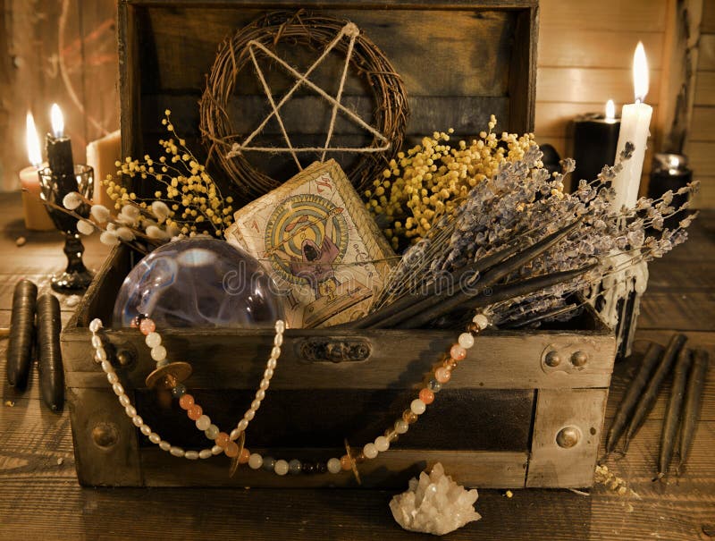 Old witch box with tarot cards, healing herbs and crystal ball on the table. Wicca, esoteric, divination and occult background with vintage magic objects for mystic rituals. Old witch box with tarot cards, healing herbs and crystal ball on the table. Wicca, esoteric, divination and occult background with vintage magic objects for mystic rituals