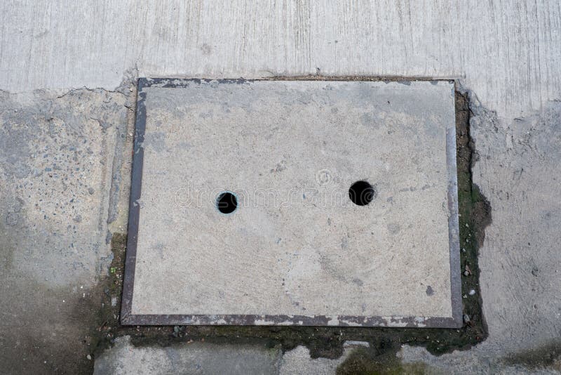 Gammal konkret rörlockplatta på vägen fotografering för bildbyråer Gammal konkret rörlockplatta på vägen fotografering för bildbyråer