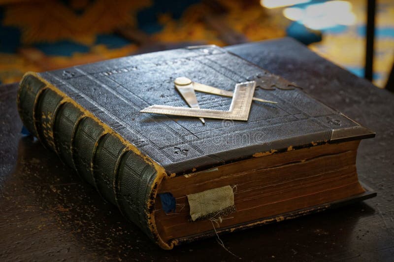 Gammal, masoniskt helig, bibelbok med mörka sidor och gamla bokmärken i mörkbrun läderomslag med kvadratisk och