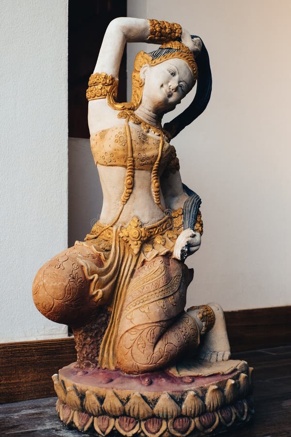 Gammal mortelstaty av kvinnan som bär den thai klänningen som knäfaller på lotusblomman på hemmet, tappning royaltyfri fotografi Gammal mortelstaty av kvinnan som bär den thai klänningen som knäfaller på lotusblomman på hemmet, tappning royaltyfri fotografi