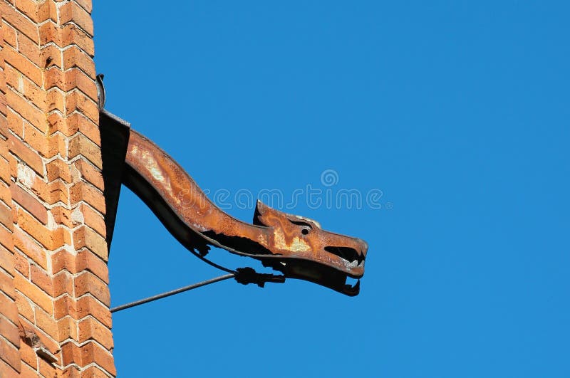 Gammal rostig dekorativ avloppsränna mot bakgrund för blå himmel royaltyfri foto Gammal rostig dekorativ avloppsränna mot bakgrund för blå himmel royaltyfri foto