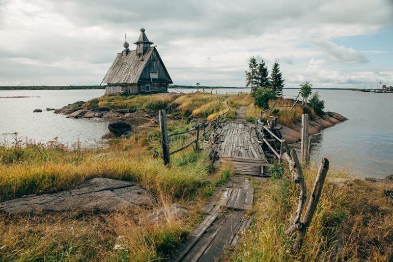 Gammal rysk ortodox träkyrka i byn Rabocheostrovsk, Karelia Övergiven kyrka på kustlinjen royaltyfria bilder Gammal rysk ortodox träkyrka i byn Rabocheostrovsk, Karelia Övergiven kyrka på kustlinjen royaltyfria bilder