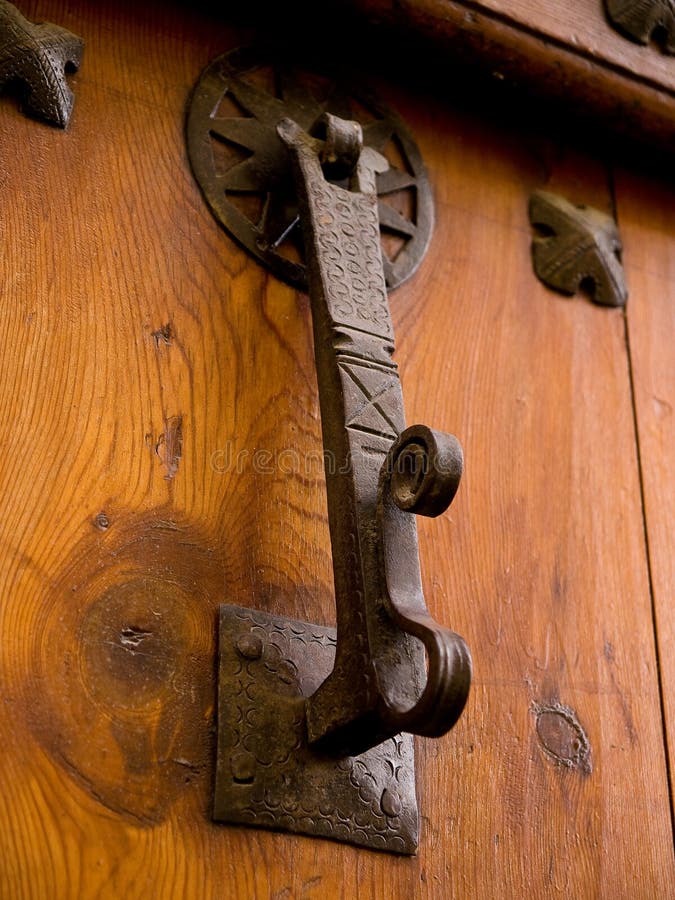 Detail an old knocker and wrought iron rivets placed on an old wooden door 6. Detail an old knocker and wrought iron rivets placed on an old wooden door 6