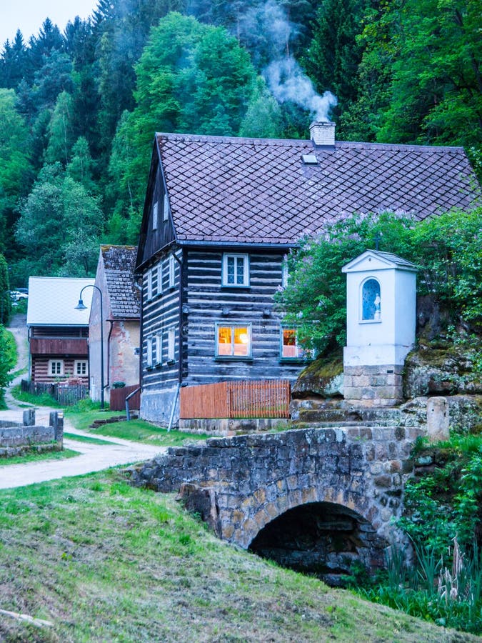 Gammal traditionell timrad stuga med romantiker med stenbron på aftontid Tjeckisk lantlig arkitektur arkivfoto Gammal traditionell timrad stuga med romantiker med stenbron på aftontid Tjeckisk lantlig arkitektur arkivfoto