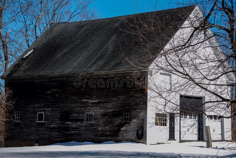 Gammal vit- och bruntNew England ladugård i ett snöig fält royaltyfria foton Gammal vit- och bruntNew England ladugård i ett snöig fält royaltyfria foton