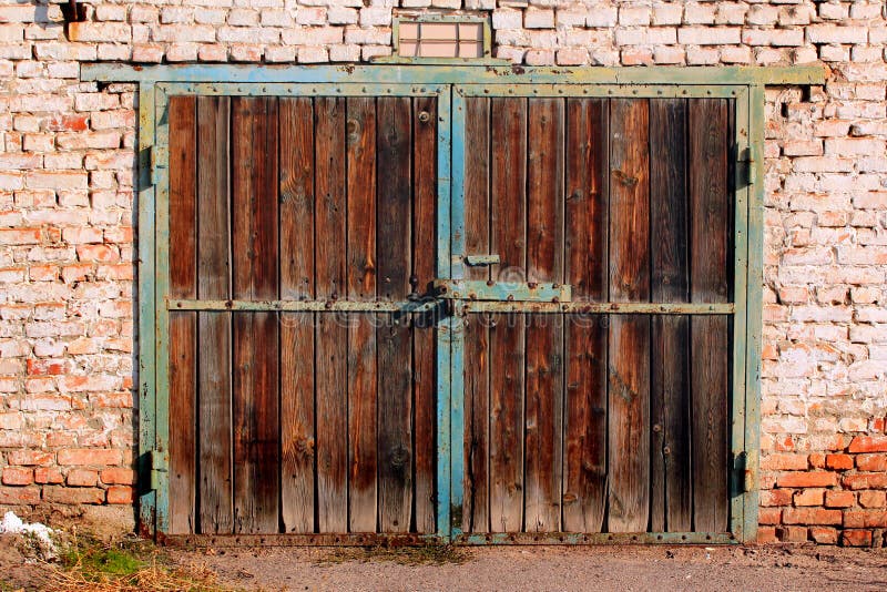 Gammala dörrar i trägarage Flänsfärg och rost på grindar till övergivna byggnader