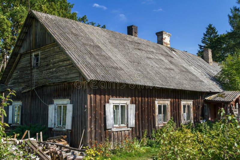Gammalt lantligt hus som täckas med eternittaket fotografering för bildbyråer