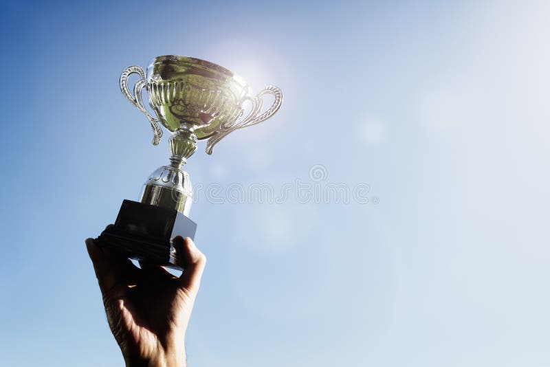 Ganador sosteniendo un primer trofeo deportivo