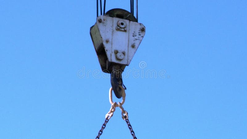 Gancho de grúa de construcción con soga de soplo de gancho de carga contra cielo azul claro.