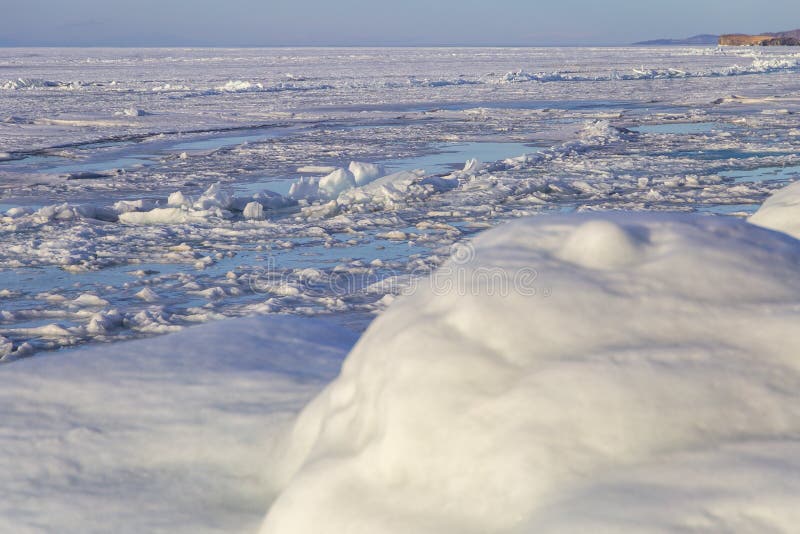 Ganci sulla superficie del ghiaccio blu Laghi congelati sulle montagne invernali Sta nevicando Lake Baikal Inverno fotografia stock Ganci sulla superficie del ghiaccio blu Laghi congelati sulle montagne invernali Sta nevicando Lake Baikal Inverno fotografia stock