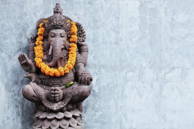 Ganesha sitting in meditating yoga pose in hindu temple