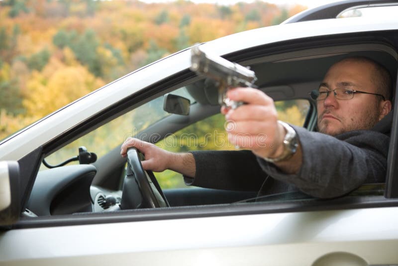 Muž pištole riadenie auto.