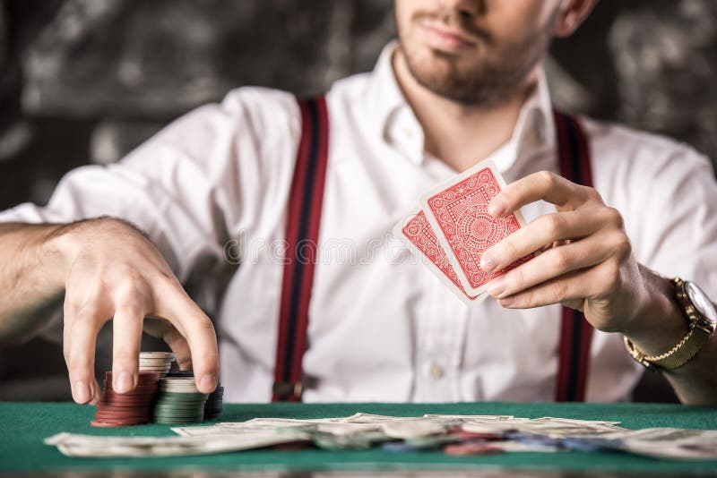 Close-up hand of young man, while playing poker game, with money and chips. Close-up hand of young man, while playing poker game, with money and chips.