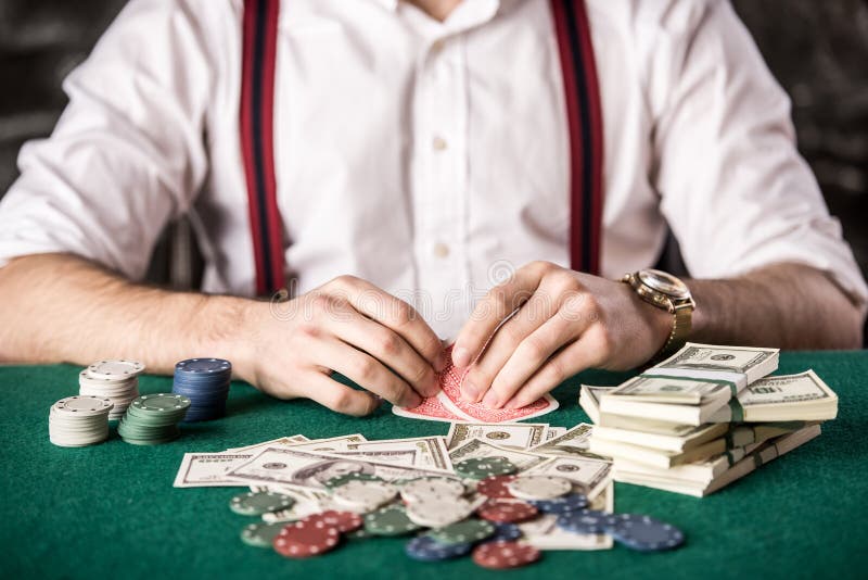 Close-up hand of young man, while playing poker game, with money and chips. Close-up hand of young man, while playing poker game, with money and chips.
