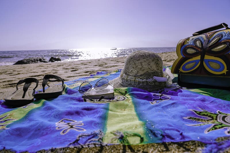 Ganhos na praia com os óculos de proteção do chapéu dos deslizadores e um saco imagens de stock Ganhos na praia com os óculos de proteção do chapéu dos deslizadores e um saco imagens de stock