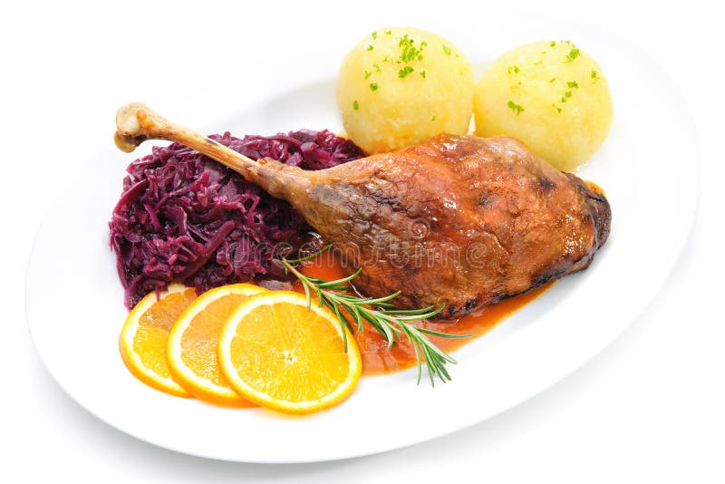 Crusty goose leg with braised red cabbage and dumplings isolated on white. Crusty goose leg with braised red cabbage and dumplings isolated on white