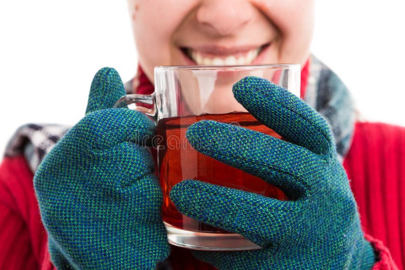 Gants de port de sourire et tenir de femme le thé chaud images libres de droits Gants de port de sourire et tenir de femme le thé chaud images libres de droits