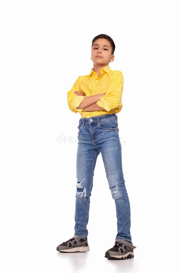 Ganzaufnahme des ernsten Jungen mit Arme gekreuztem tragendem gelbem Hemd und Jeans auf einem Weiß stockfoto Ganzaufnahme des ernsten Jungen mit Arme gekreuztem tragendem gelbem Hemd und Jeans auf einem Weiß stockfoto