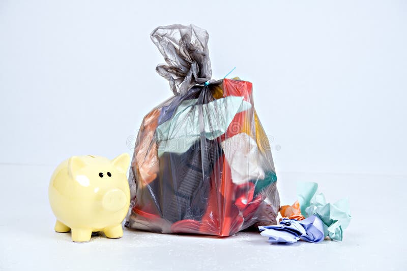 Garbage bag with defferent content with yellow piggy bank