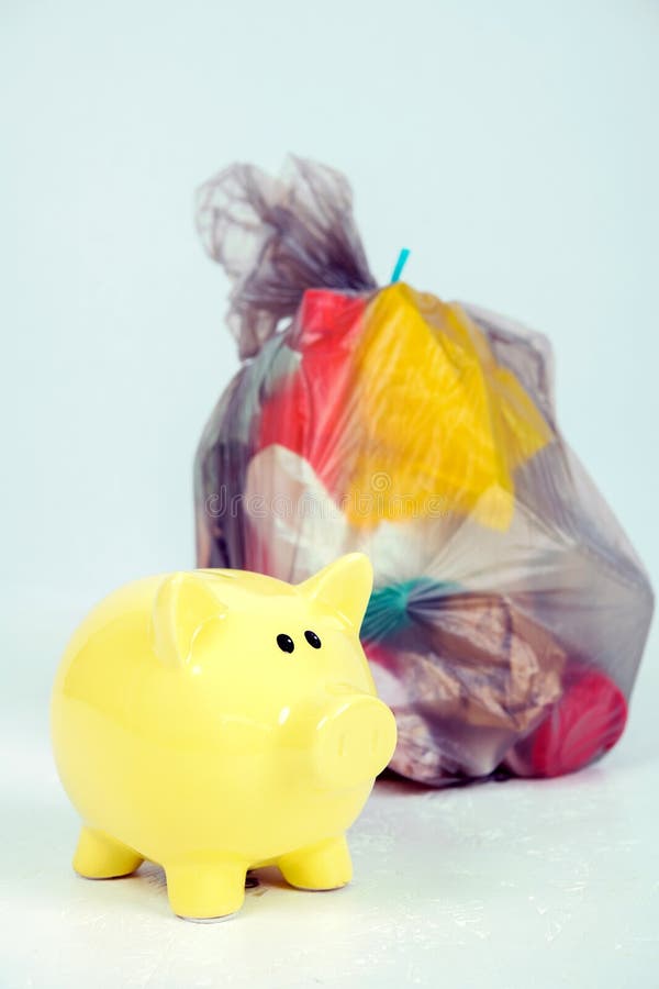 Garbage bag with defferent content with yellow piggy bank