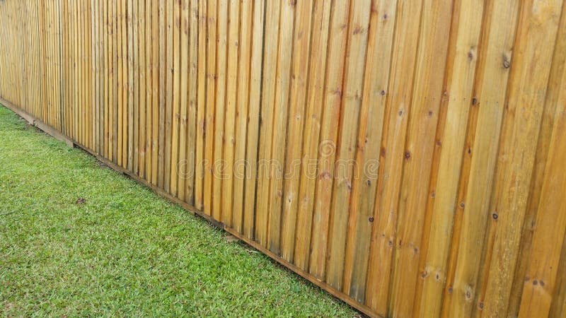 New clean garden fence with a little bit of green lawn