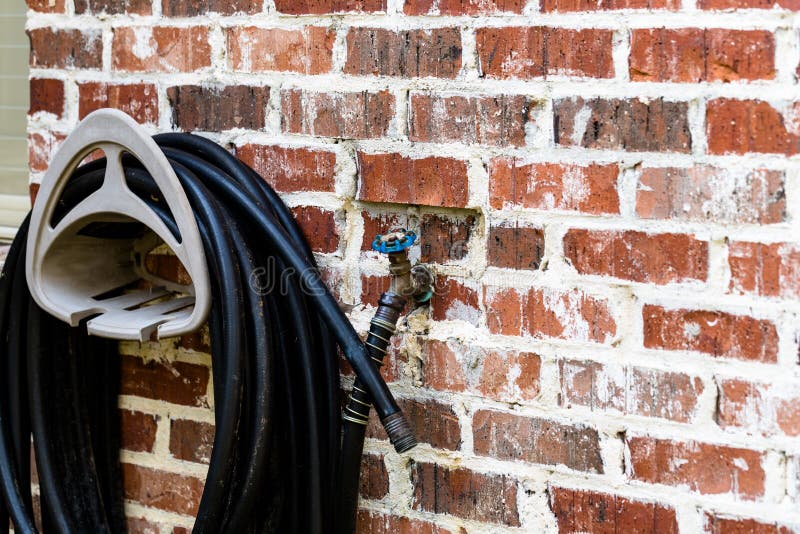 Garden hose on brick wall stock image. Image of large 84190035