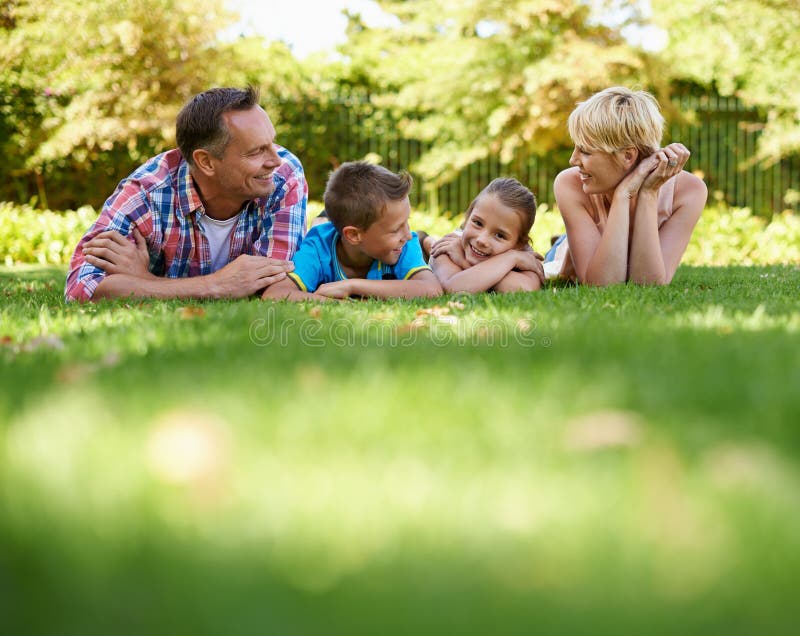 Garden, park and happy family relax on grass in summer or parents and children together. Mother, father and kids smile