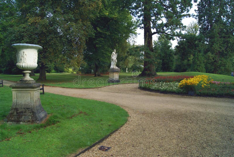 Garden path with an ornament and Roman statue on a plinth
