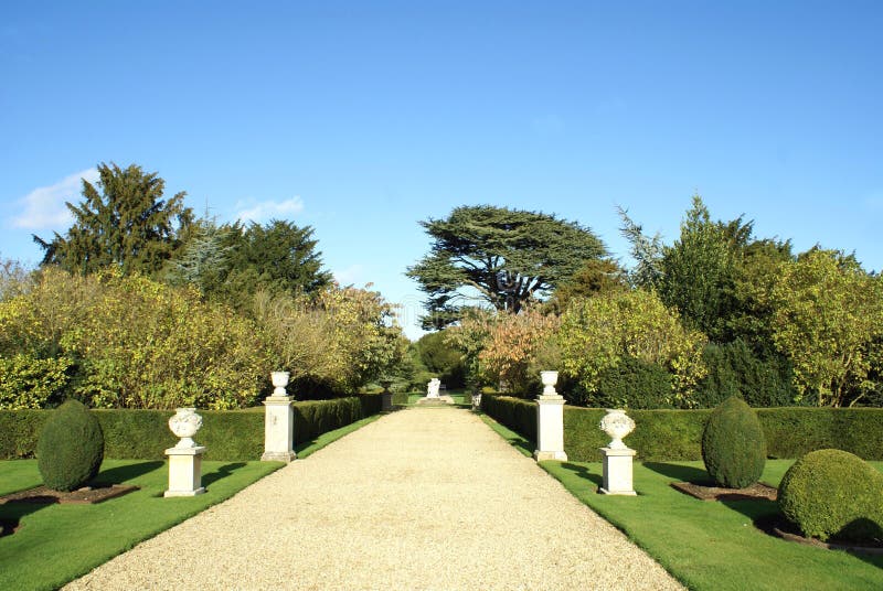 Garden pathway with sculptured urns and topiary trees