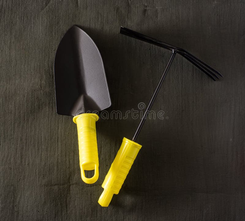Garden Tools Shovel and Rake on a Dark Tarpaulin. Stock Image Image